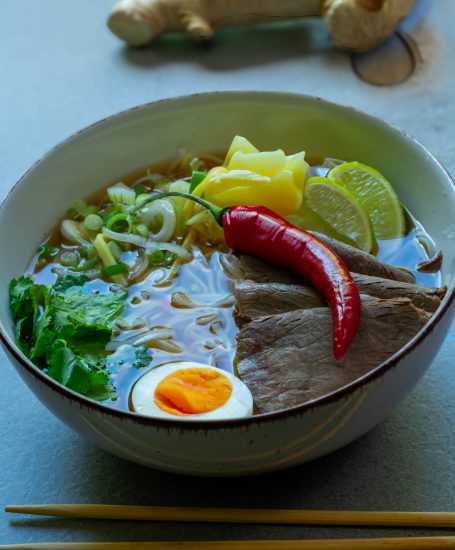 Schüssel mit Pho, Gemüse, Ei, Limette und scharfer Chilischote.
